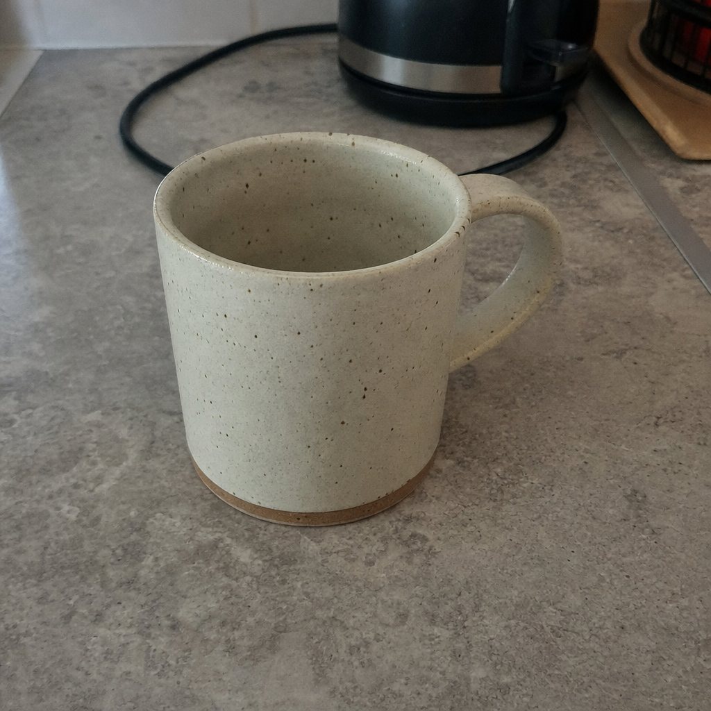 Original: speckled ceramic mug on a grey kitchen counter with a kettle cord behind it